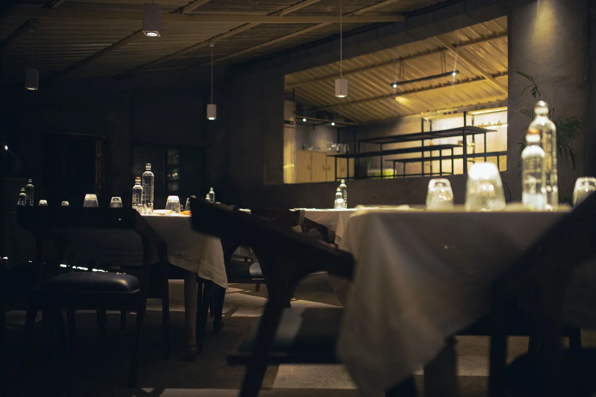 The dining room at dusk, tables set and lamps glowing