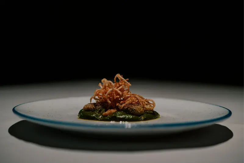 Seared potato and eggplant dumplings topped with crisp onions