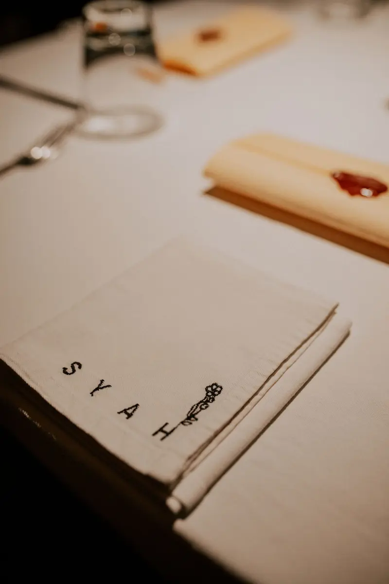 A folded Syah napkin on a set table