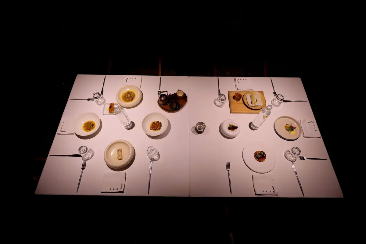 A tasting menu laid out course by course on a white table